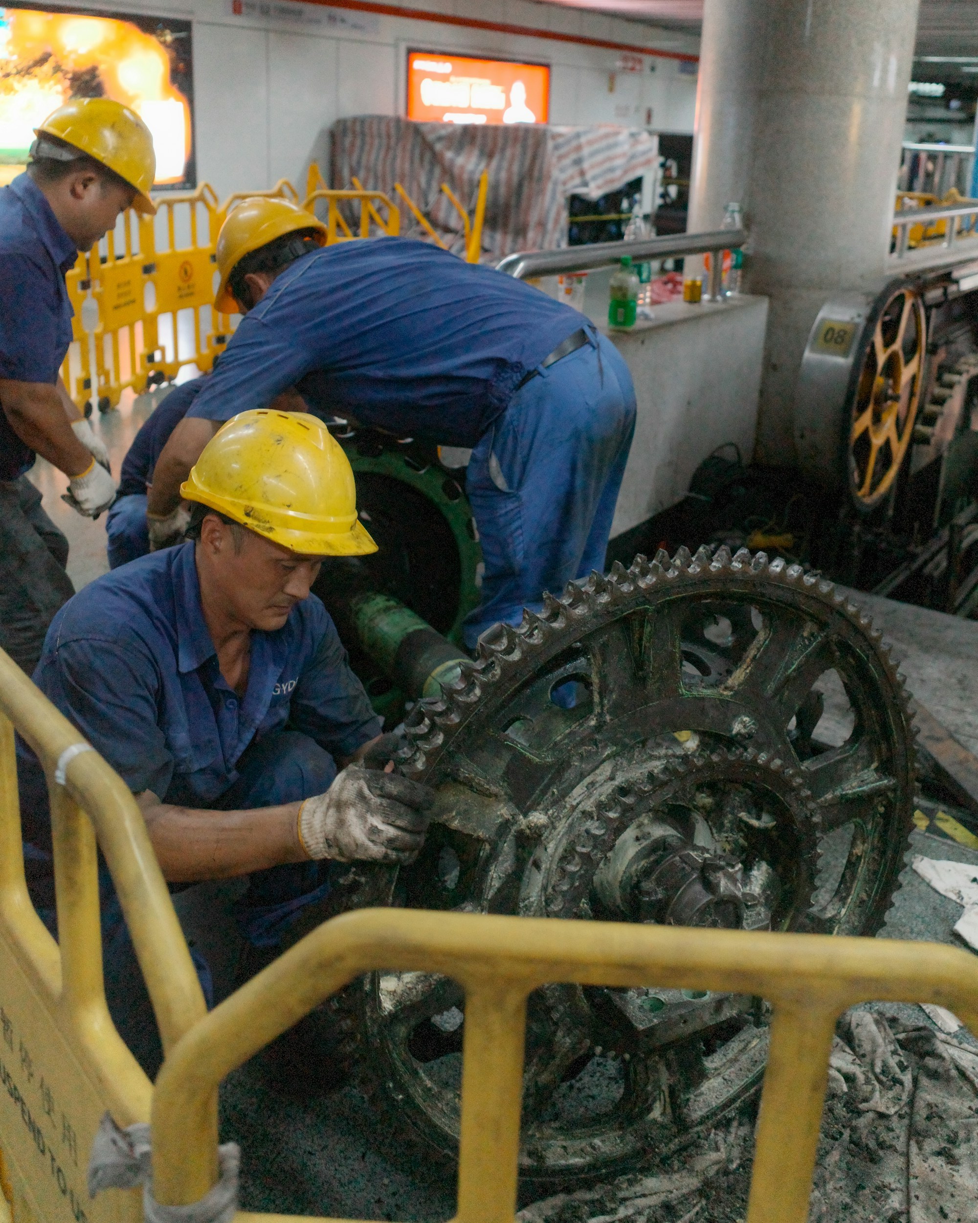 Maintenance workers repairing a large gear.