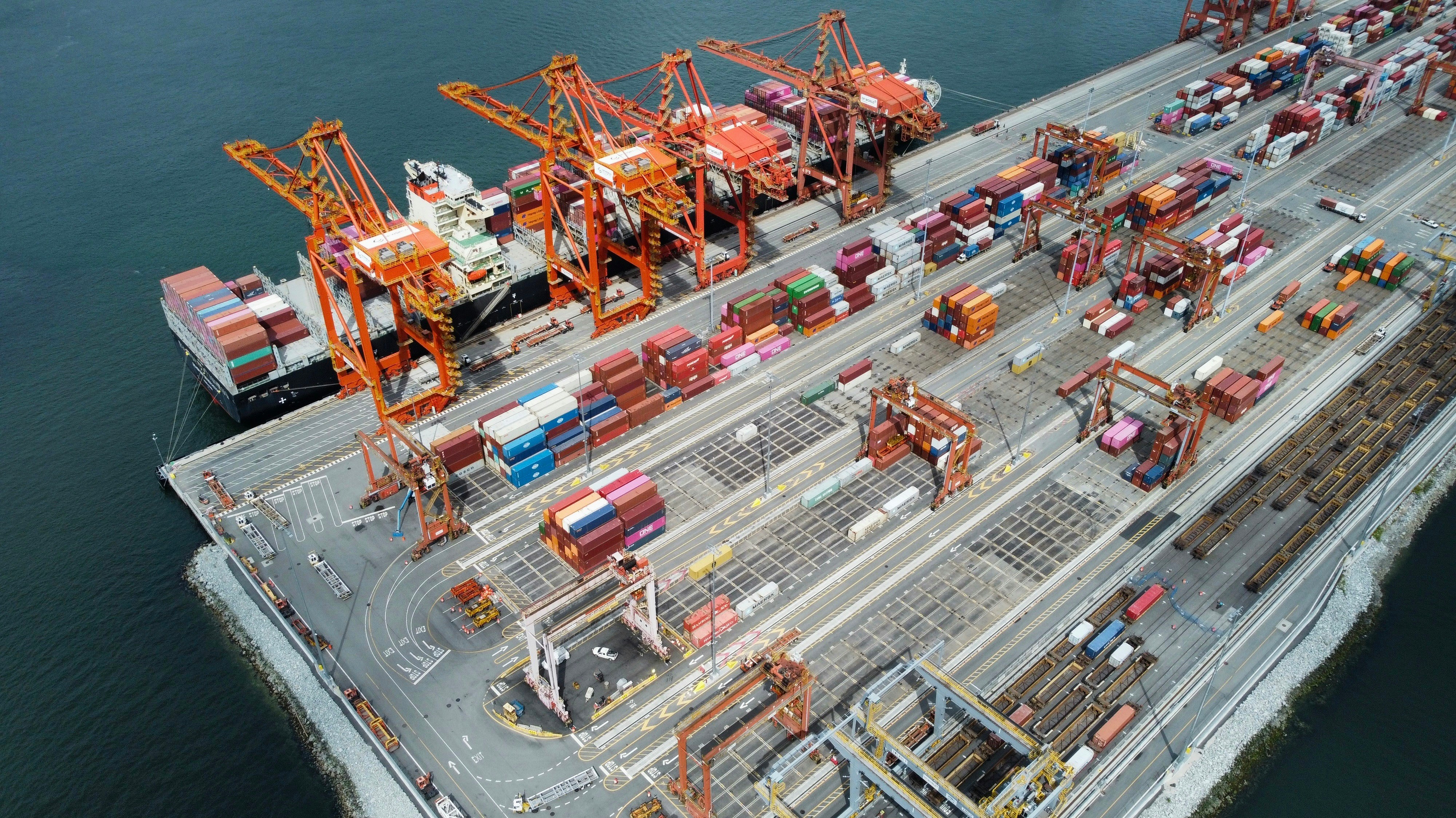 Containers and industrial cargo moving through a working port.