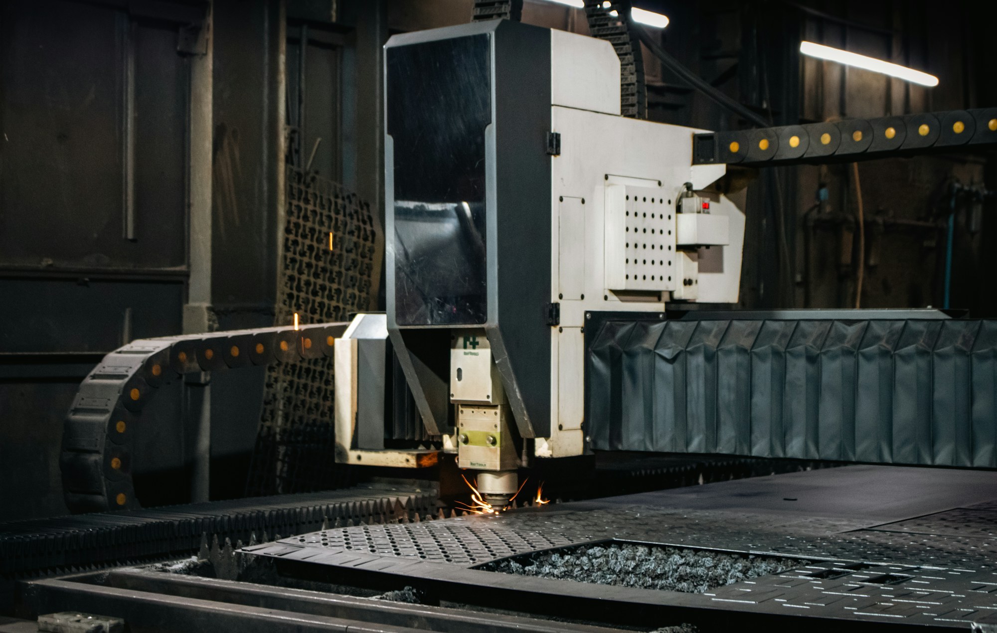 A laser cutting a metal sheet in a workshop.