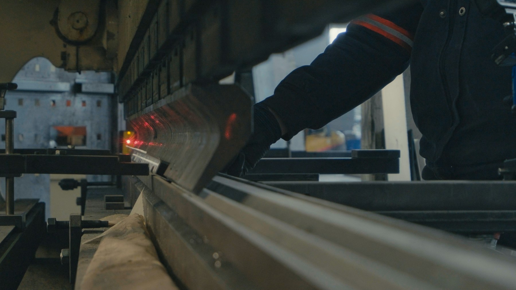 An operator works at a press brake in a metal fabrication shop.