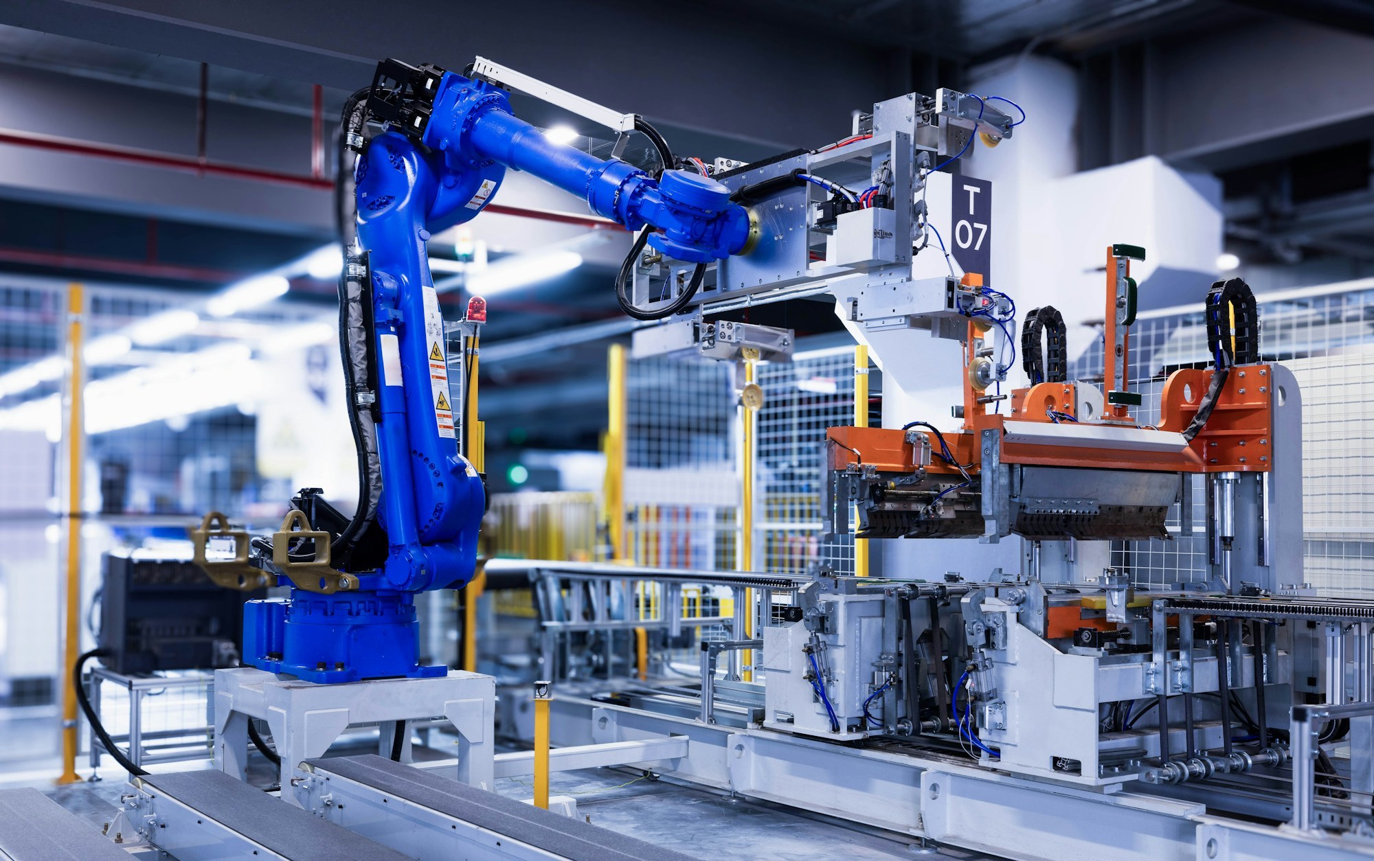 An industrial robot moving a part on an assembly line.